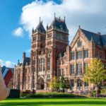 University campus in the United Kingdom with an international student walking toward a historic academic building.